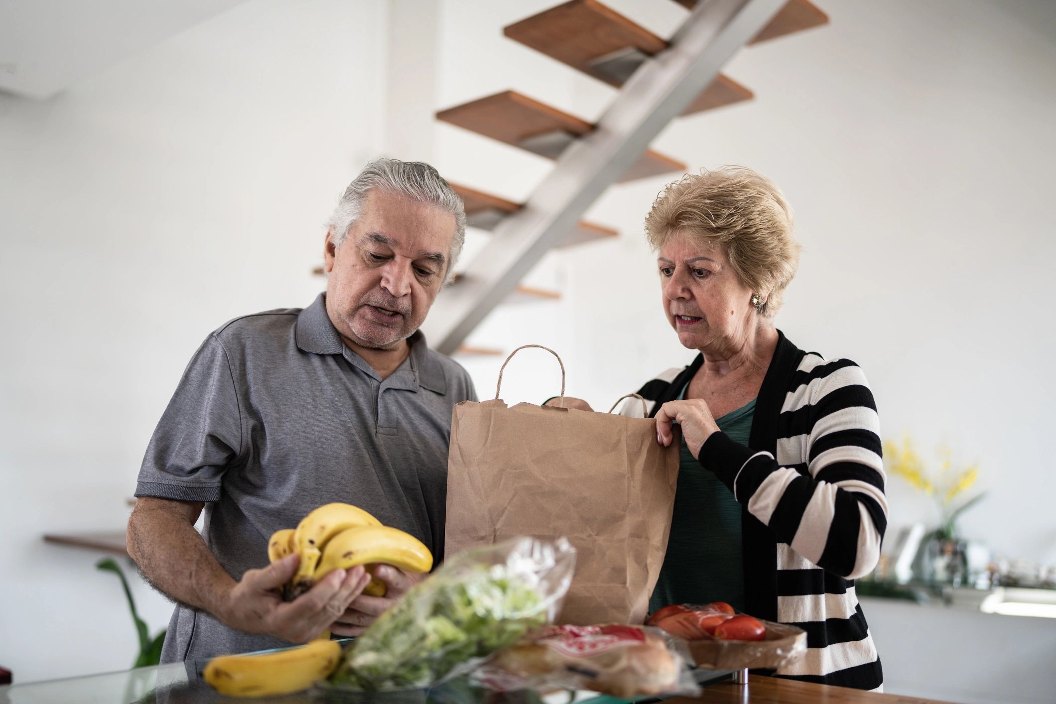 Senior couple unpacking groceries at home